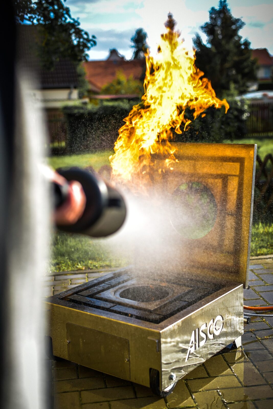 Praktische Löschübung – Person löscht ein kontrolliertes Feuer mit dem Feuerlöscher