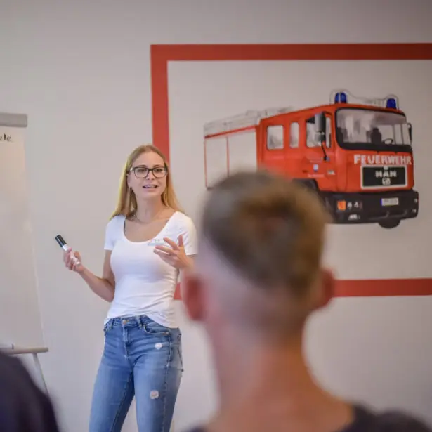 Trainerin erklärt Brandschutz-Inhalte am Whiteboard